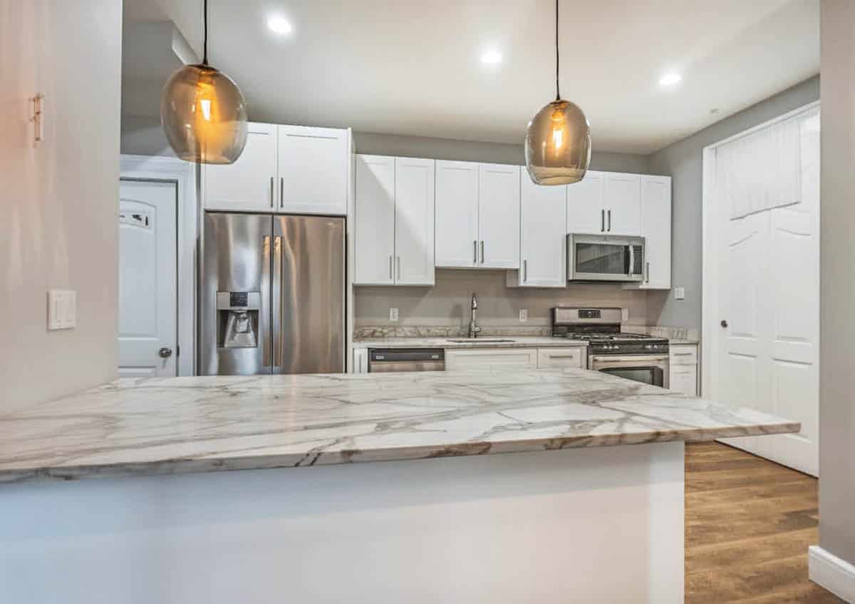 Kitchen with 4 inch quartz backsplash and countertops with white cabinets