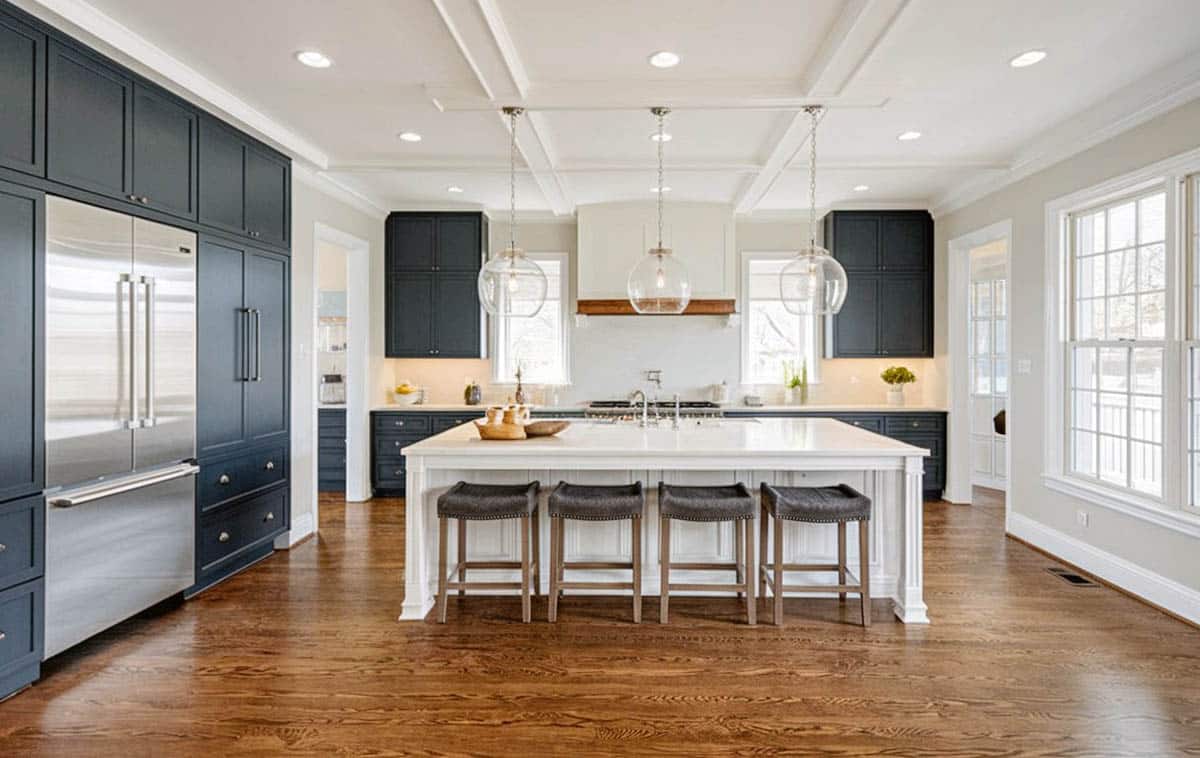 open concept kitchen with black cabinets white island and white tile backsplash