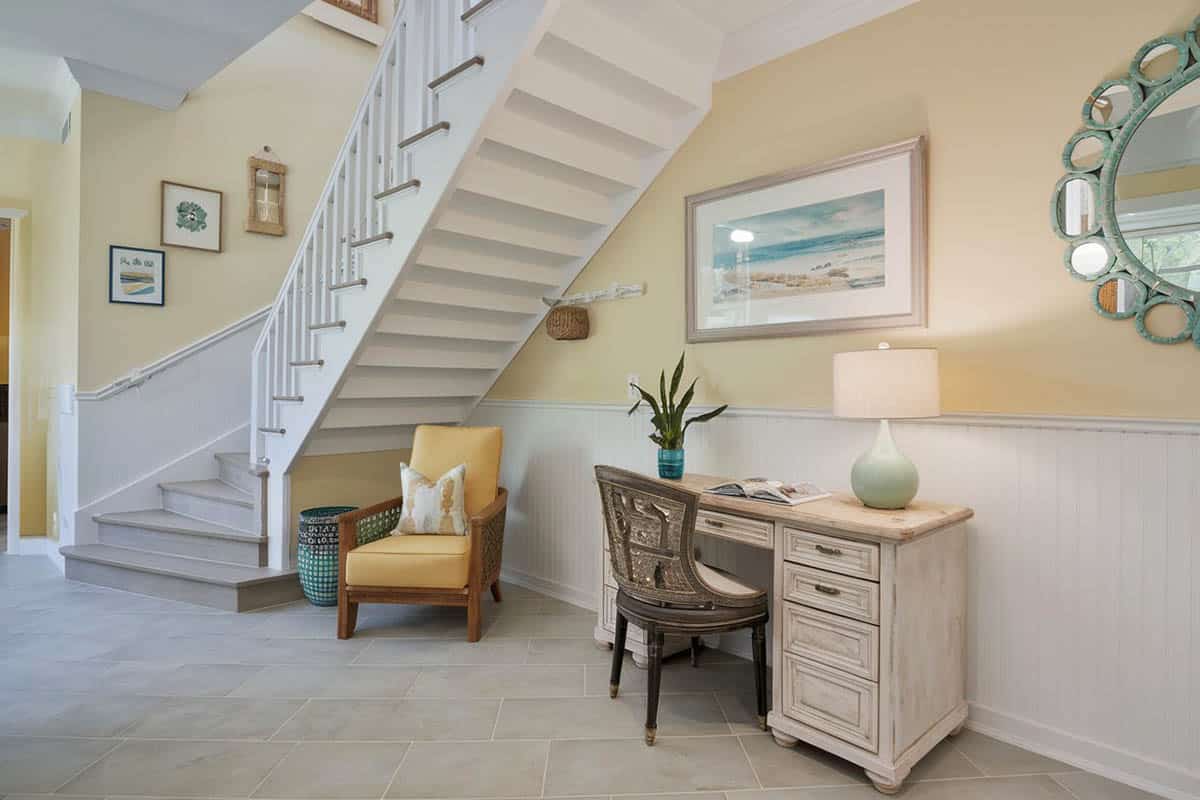 Coastal themed entryway with grey large format tiles, light yellow walls and desk