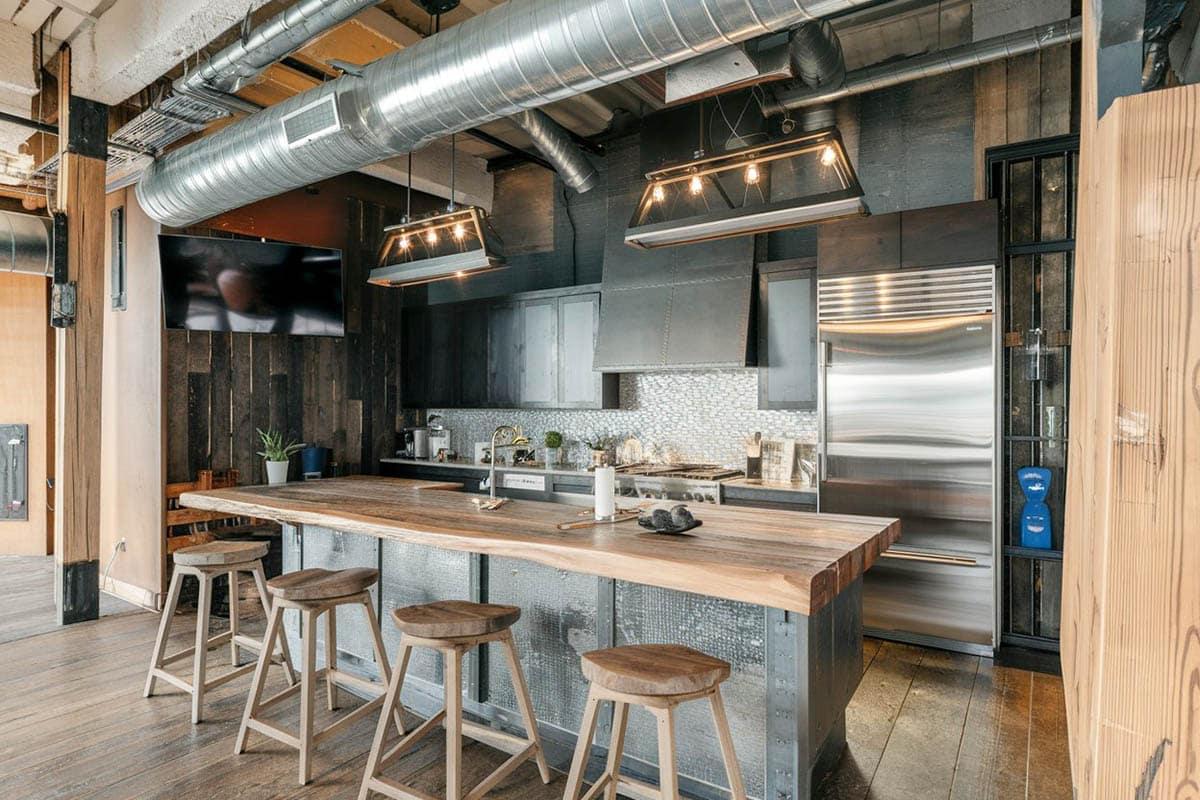 Industrial style kitchen with reclaimed wood countertop island black cabinets open duct work