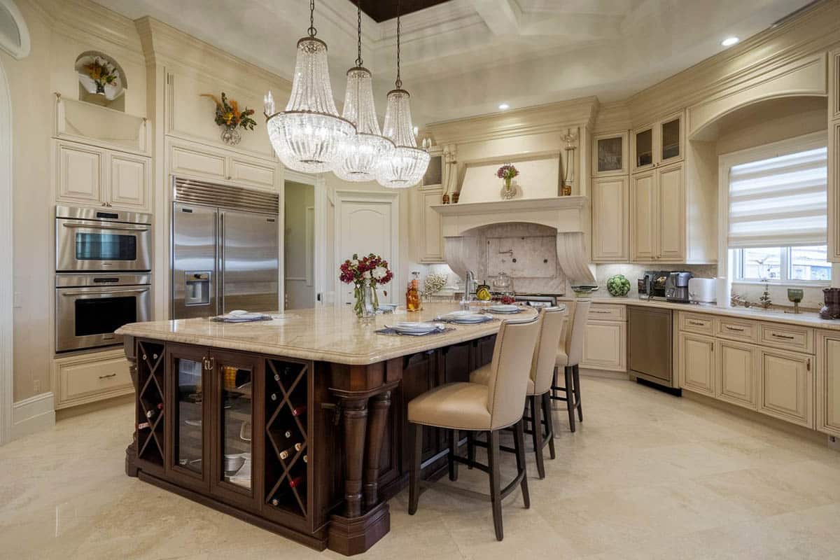 Cream cabinetry paired with wood island and honed travertine floors