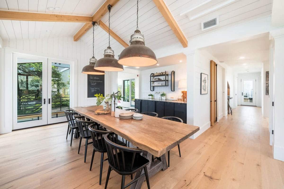 Modern farmhouse dining room with vaulted ceiling and wood beams, pendant lighting and wooden floors