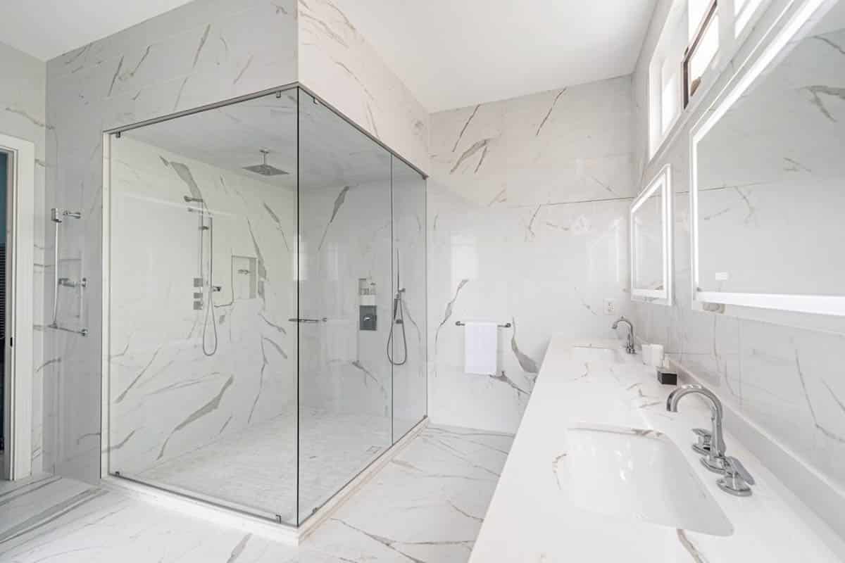 Bathroom with dual vanities and backlit mirrors