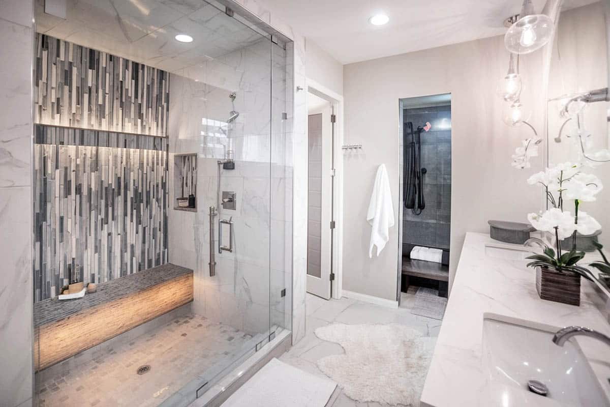 Bathroom with mosaic style shower bench and orchid on counter