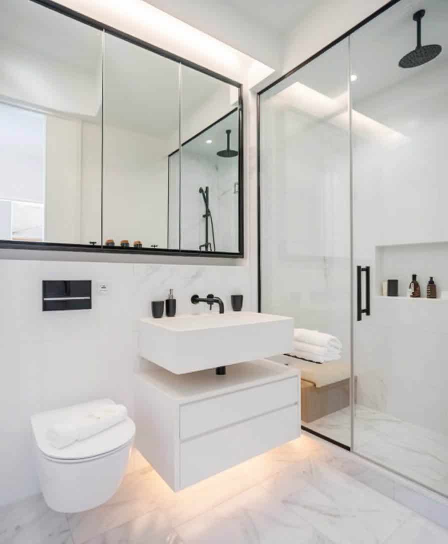 Shower with black rimmed panel mirrors and floating bench