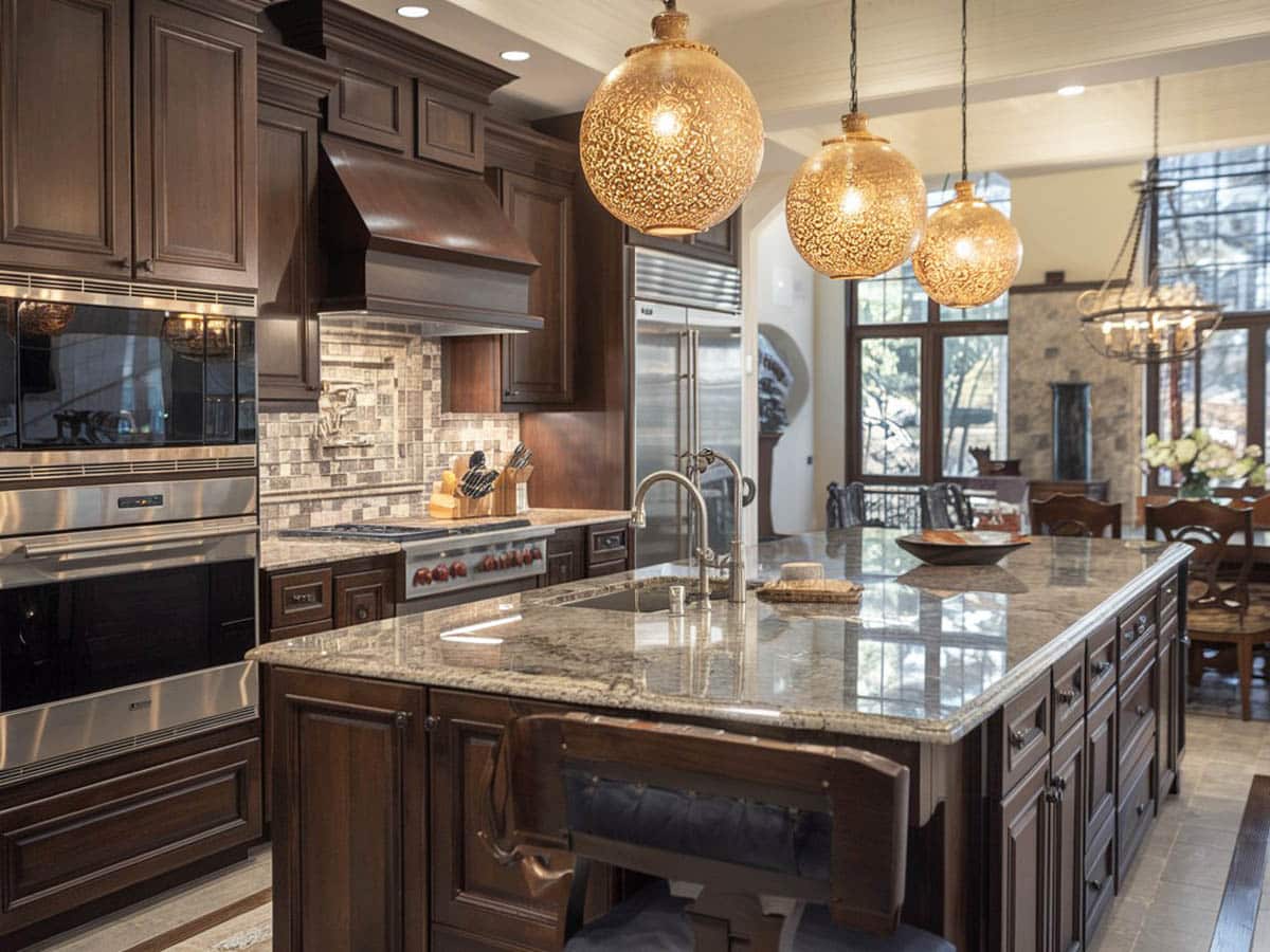 Golden globe lighting in a dark color scheme kitchen