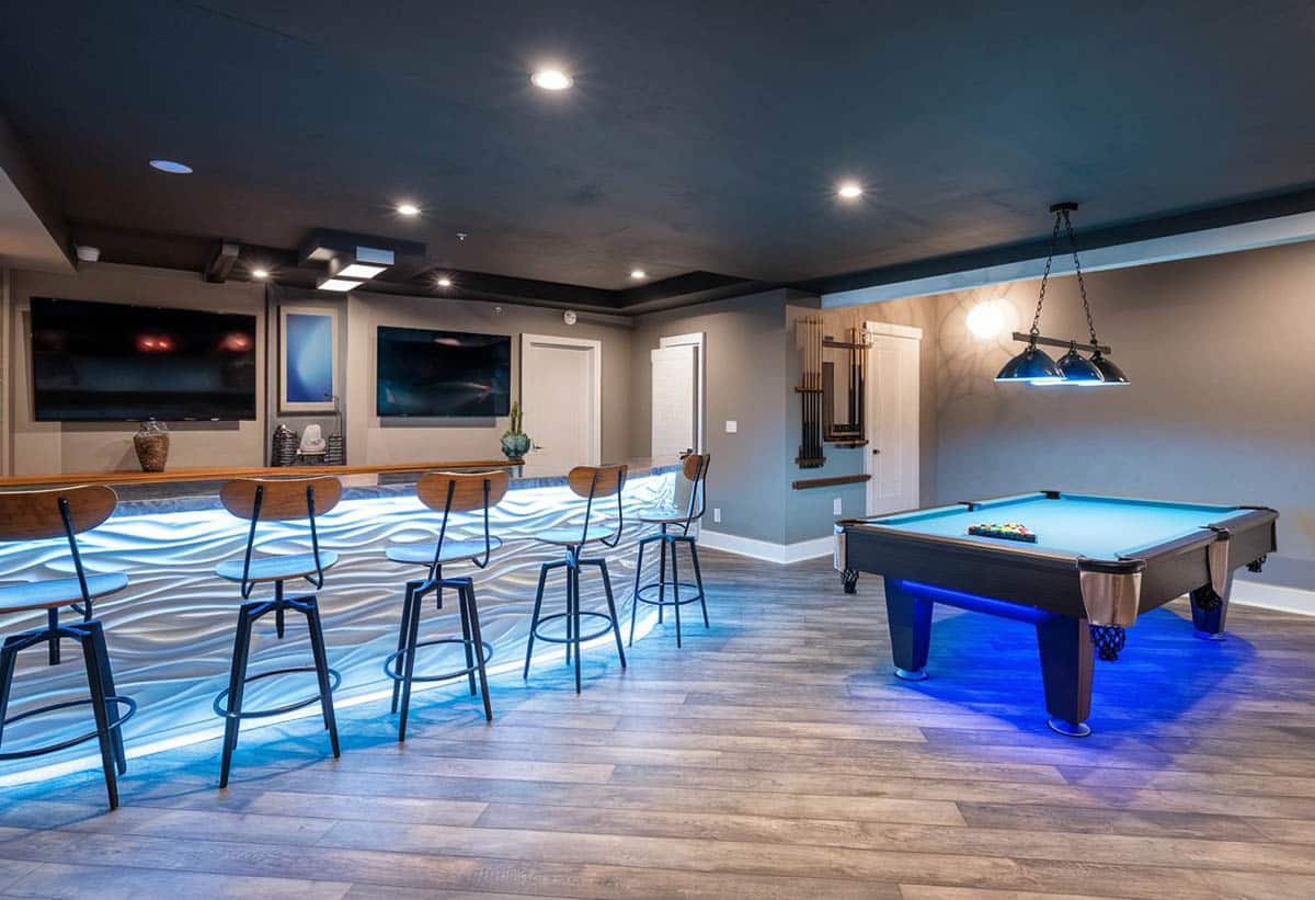 Modern gaming room with glowing bar and wood plank flooring