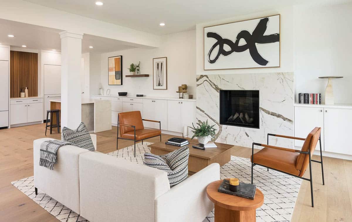 Modern living layout with kitchen, marble fireplace and wood flooring