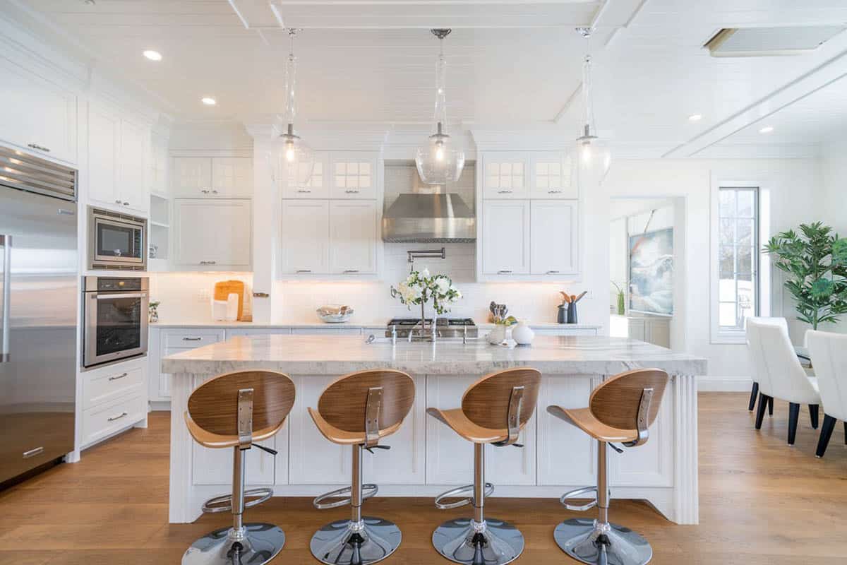 Beautiful kitchen with quartz counter island white cabinets and adjustable height swivel bar stools