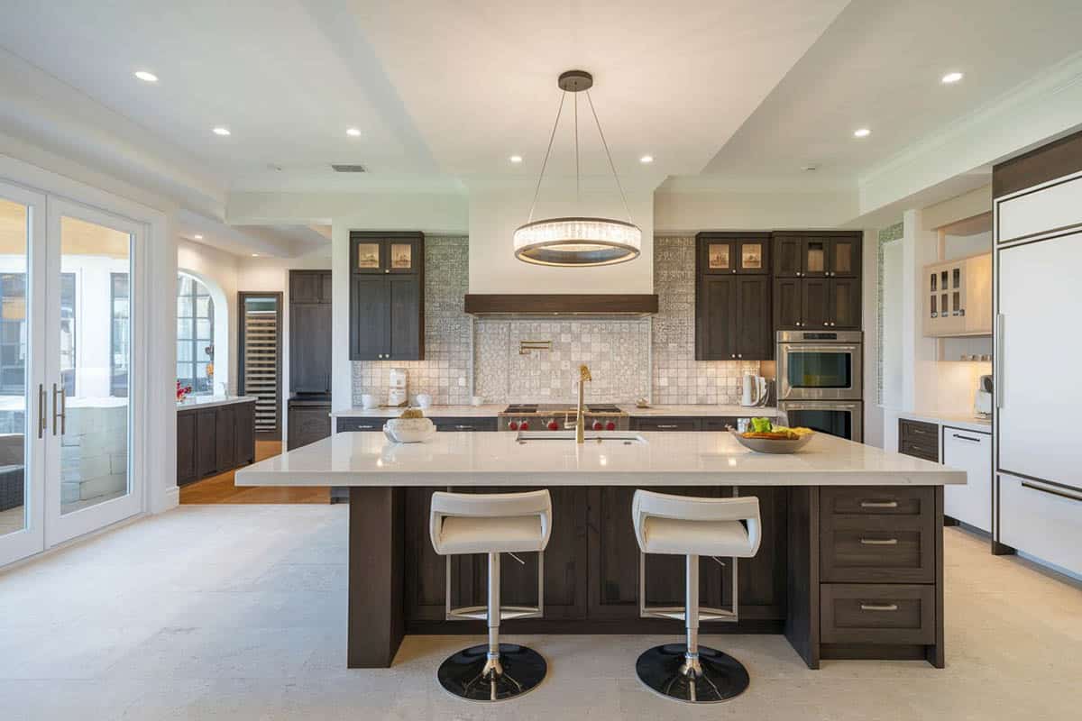 Contemporary style kitchen with meridian gray quartz counter island with chrome bar stools and brushed beige marble tile floors
