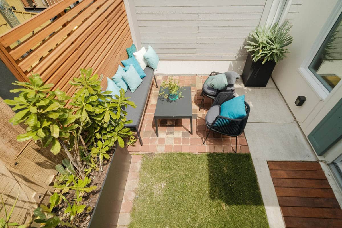 Backyard brick patio with horizontal wood privacy fence