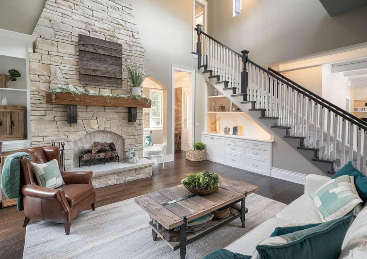 Room with stone wall and white cabinets under the staircase