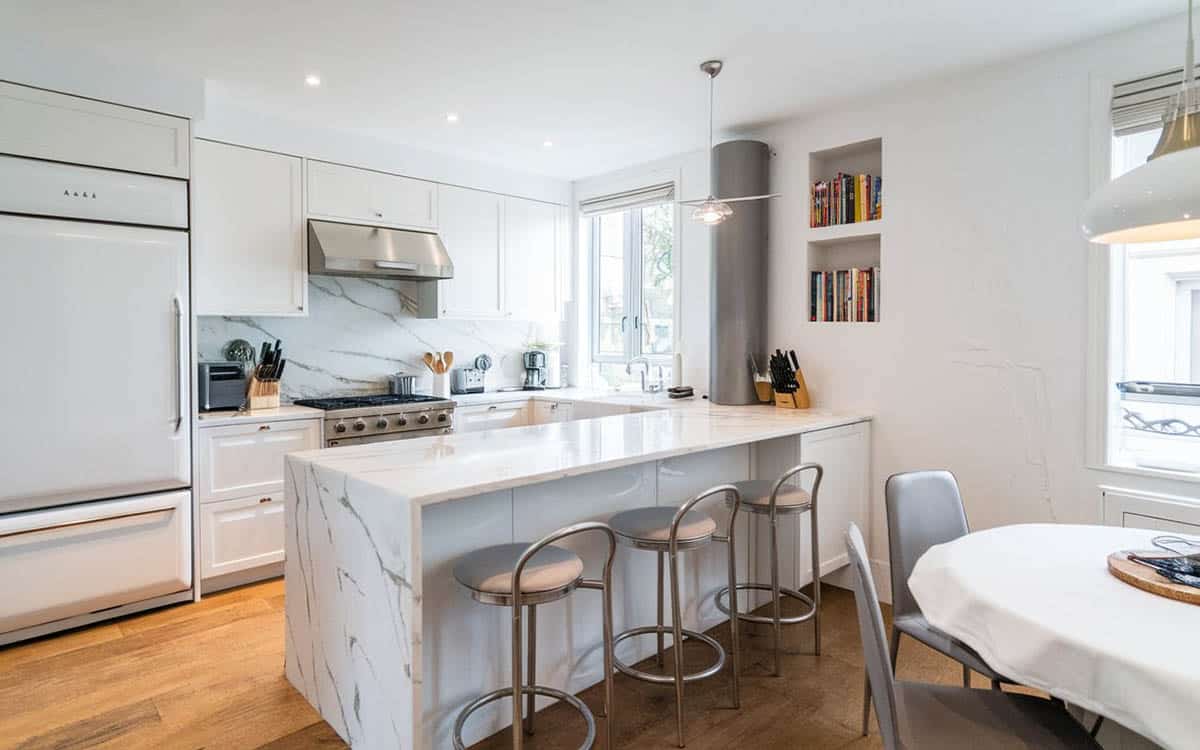 Kitchen with silver stools, wall niche, round table and island