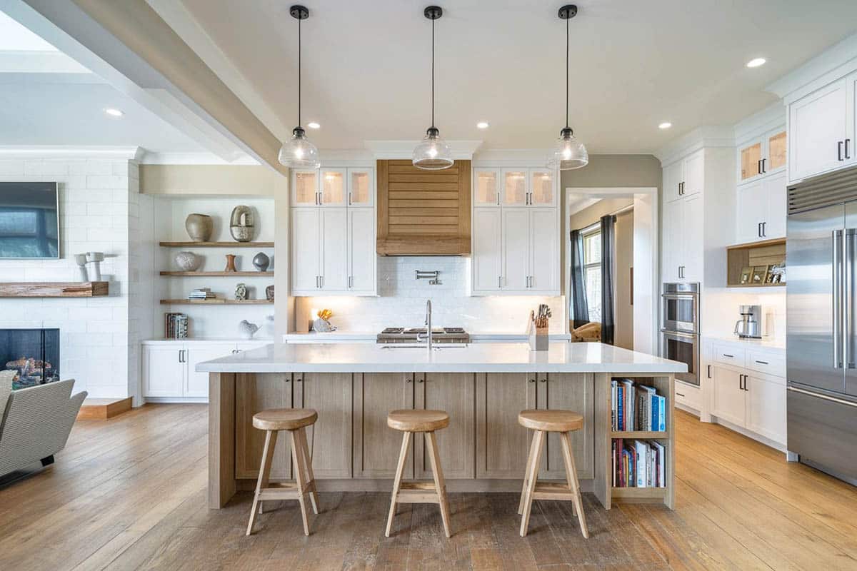 Kitchen with white counter, bar stools, sink, faucet and ceiling lights