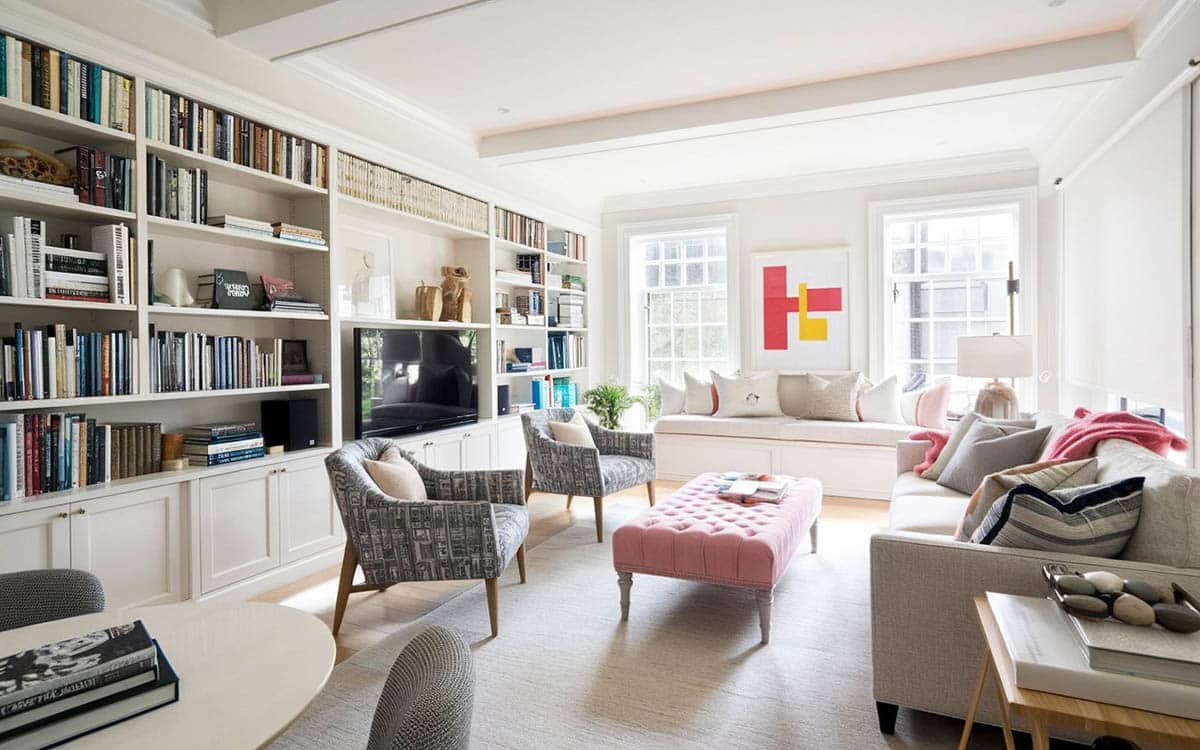 Room with maroon table, upholstered accent chairs and books on shelves