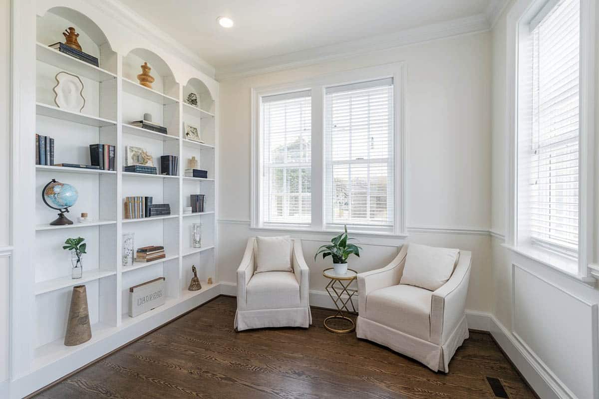 Room with white racks on walls, cream chairs and small gold table with plant