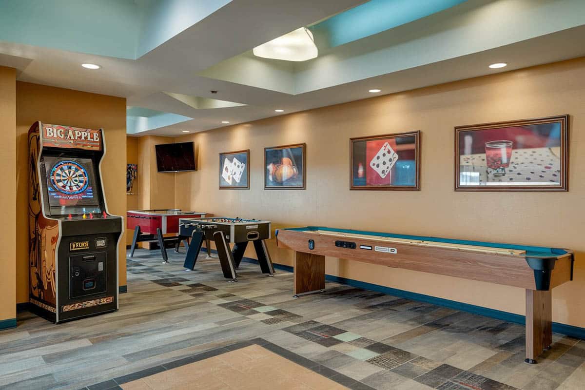 Room with full size shuffleboard table, foosball and air hockey game