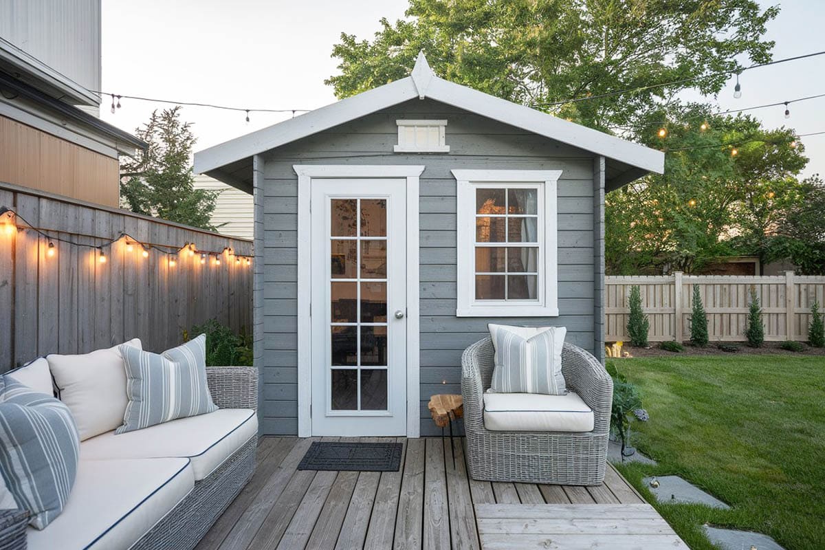 Small shed in backyard with deck and lounge chairs